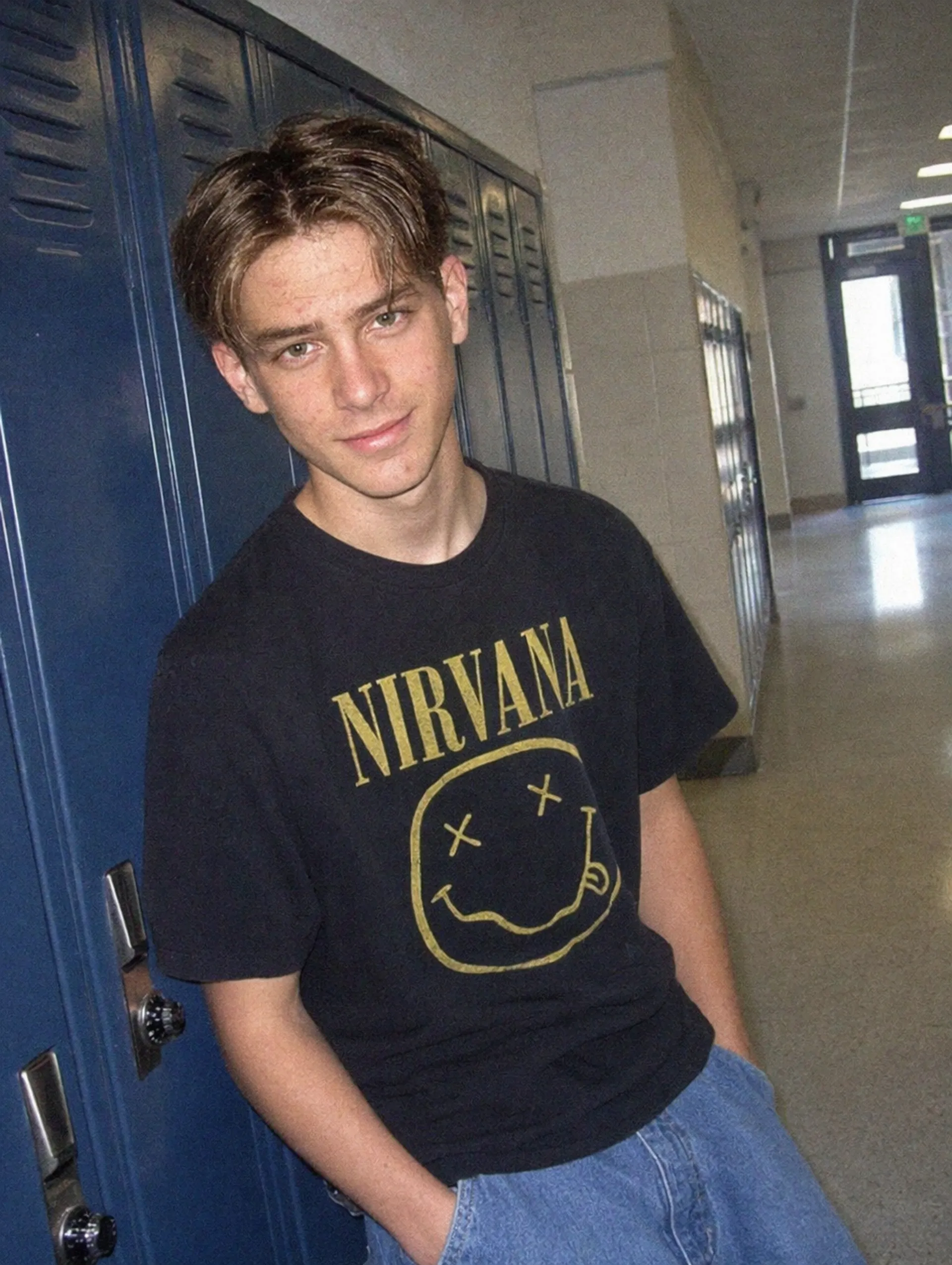 Photorealistic AI-generated image of a teenager leaning against school lockers in 1990s style