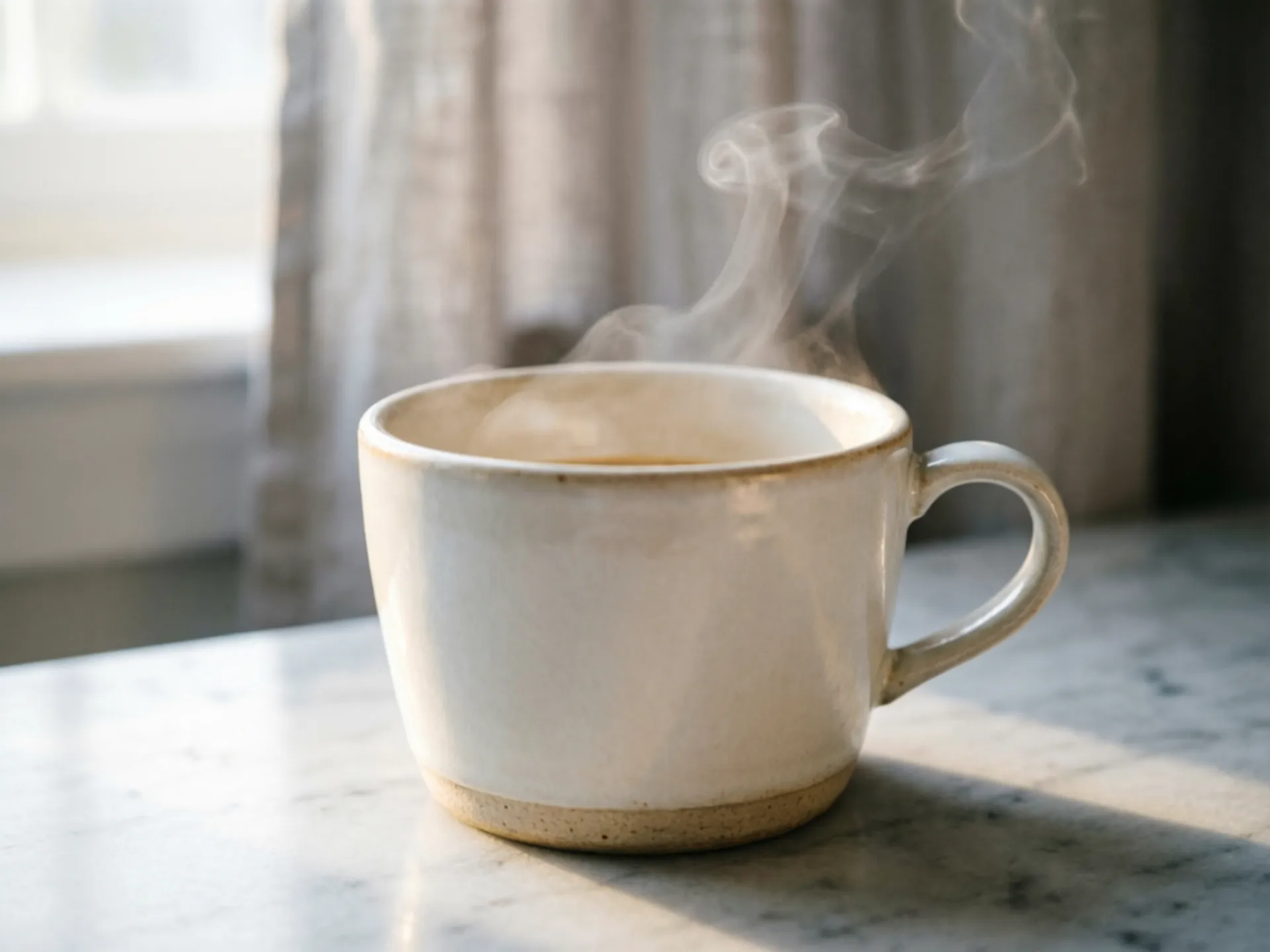 Professional product photography of a ceramic coffee mug on a marble countertop, morning light streaming through a window, steam rising from the cup, shallow depth of field, warm tones, editorial quality for a lifestyle brand