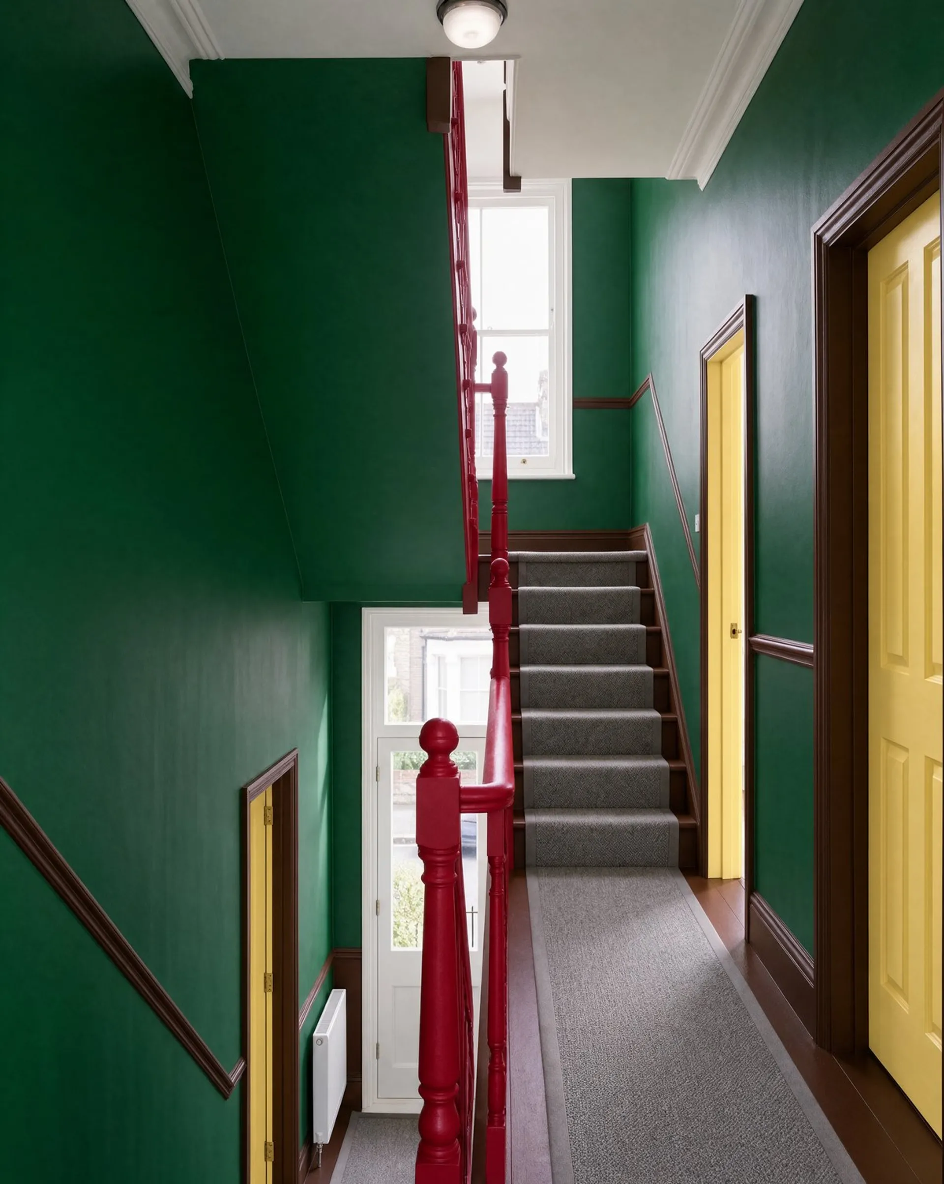 Krea 3 image of the same hallway with forest green walls, a red bannister and yellow doors